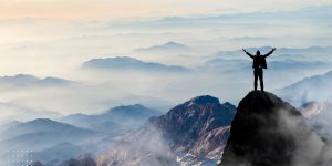 Man hands up on mountain with an incredible view